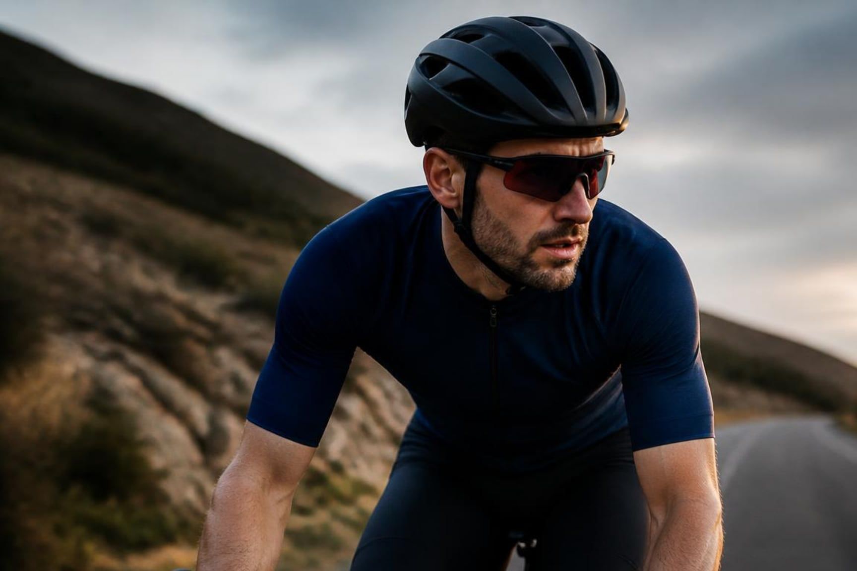 A road cyclist mid-ride on a mountain road.